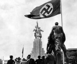 В 1937 г. в Париже прошла Всемирная выставка искусств и техники. Крупнейшими были советский и немецкий павильоны. Над советском павильоном скульптура "Рабочий и колхозница», напротив — павильон Германии, скульптура "Товарищество».